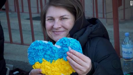 Maria Halligan segura um coração de papel feito para ela por crianças polonesas enquanto se prepara para retornar à Ucrânia.