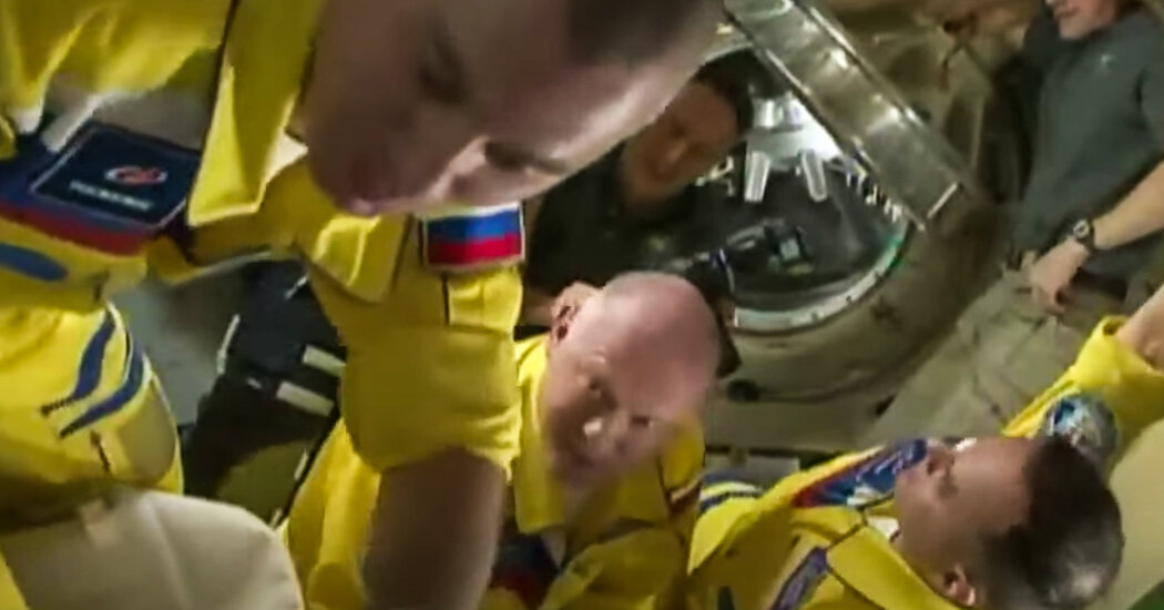 Uma pintura de cosmonautas russos da ISS em cores semelhantes às da bandeira ucraniana

