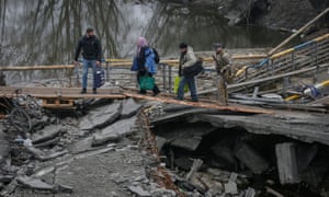 Pessoas atravessam o rio Irbin perto de uma ponte destruída enquanto são evacuadas da cidade de Irbin, em meio à invasão russa da Ucrânia, nos arredores de Kiev, Ucrânia, em 1º de abril de 2022.