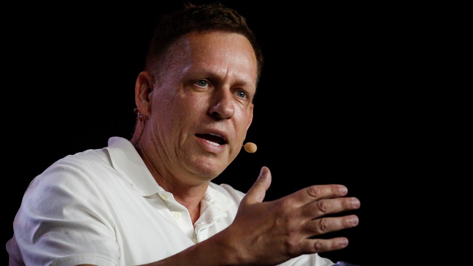 Peter Thiel, cofundador do PayPal, Palantir Technologies and Founders Fund, detém um título de US$ 100 enquanto fala durante a conferência Bitcoin 2022 no Miami Beach Convention Center em 7 de abril de 2022 em Miami, Flórida.