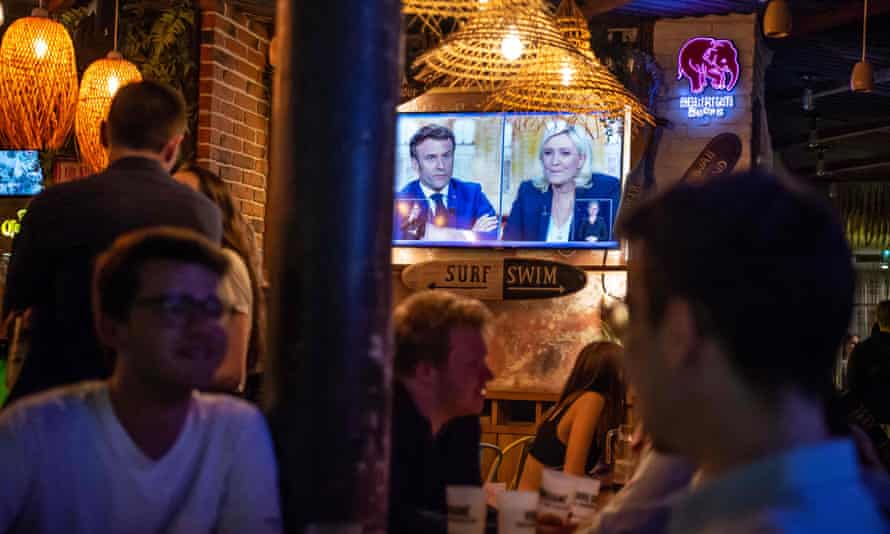 O debate é exibido em uma tela em um bar em Paris