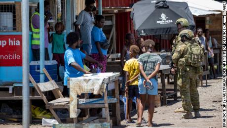 Soldados do Exército australiano conversam com moradores locais durante uma patrulha de engajamento comunitário em Honiara em 27 de novembro de 2021.