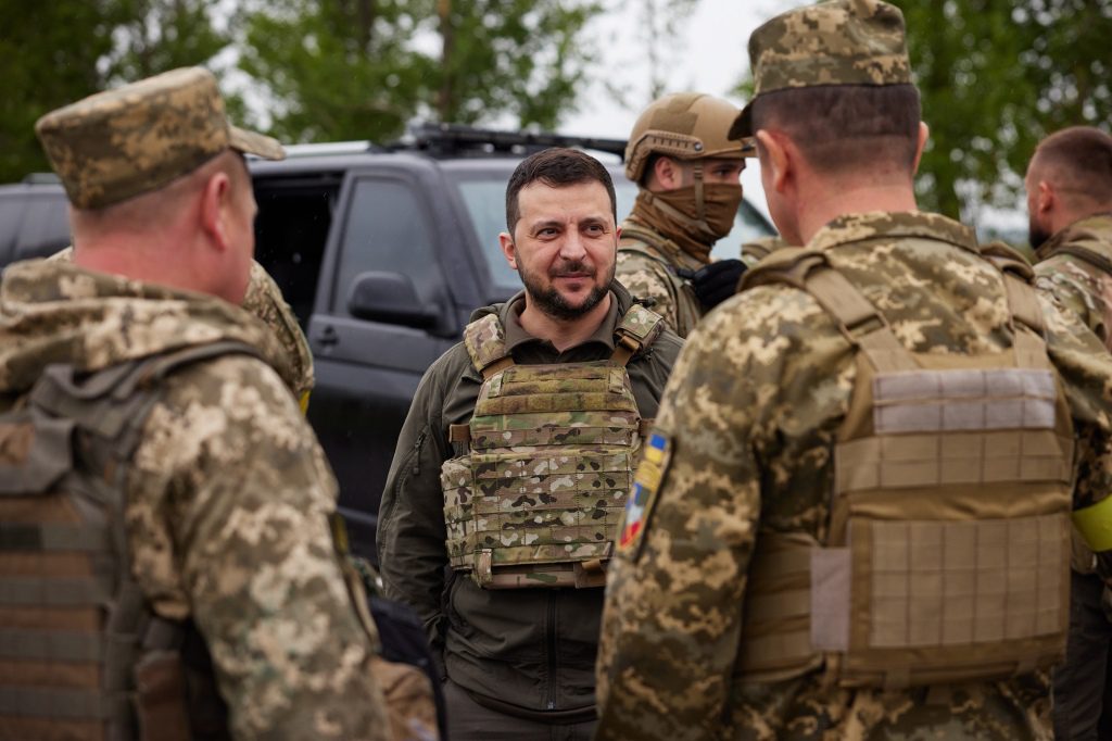 O presidente ucraniano Volodymyr Zelensky (centro) se reúne com soldados ucranianos.