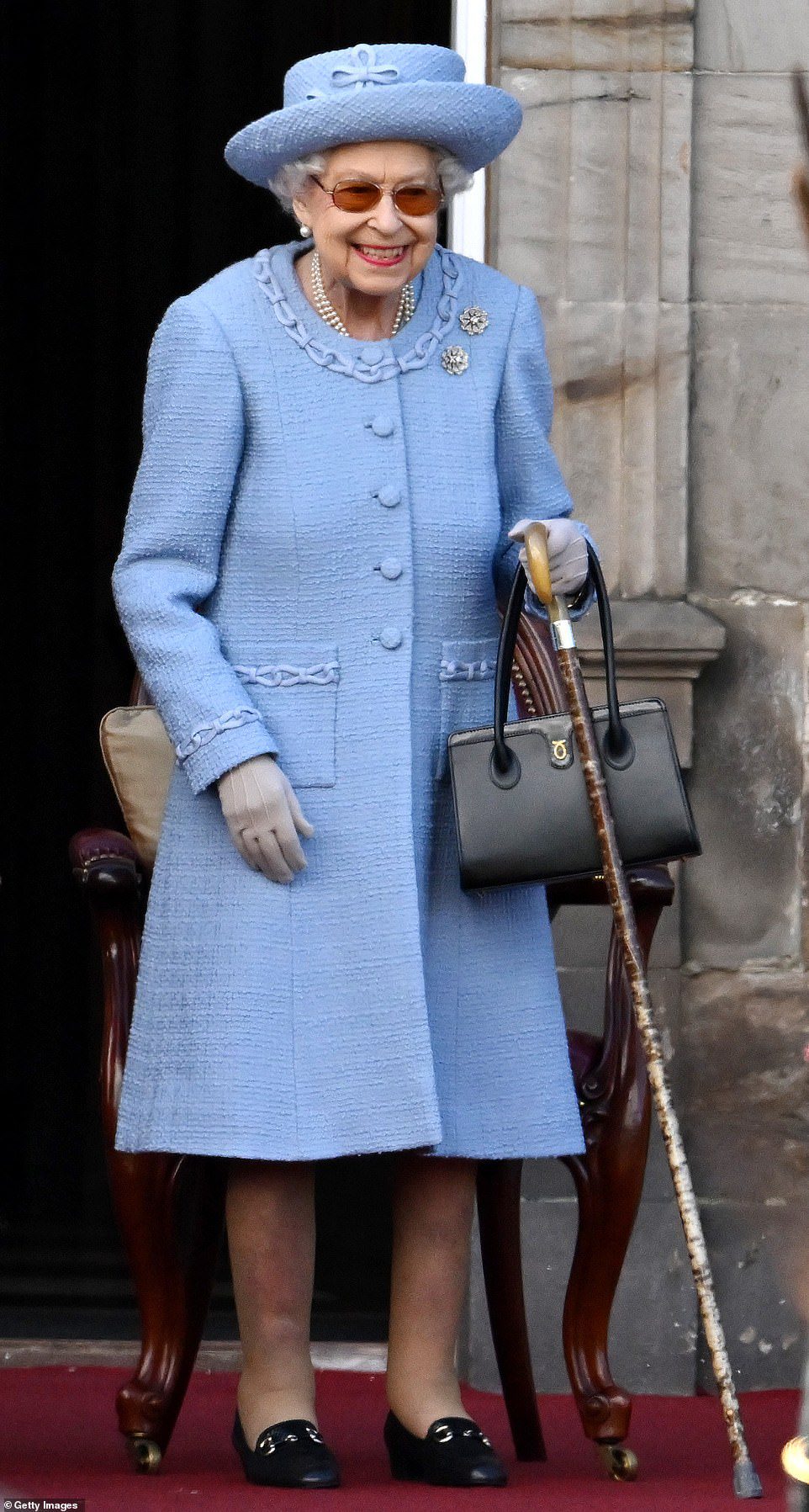 Azul radiante!  A Rainha é toda sorrisos enquanto assiste à Royal Company of Archers Reddendo Parade nos jardins do Palácio de Holyroodhouse