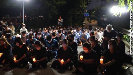 Uma pequena multidão realiza uma vigília à luz de velas em Seul em 11 de agosto para comemorar a morte de uma família depois que sua casa foi inundada por uma enchente em 8 de agosto.