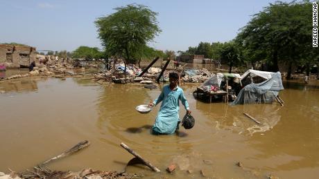 Um homem procura por pertences aproveitáveis ​​de sua casa inundada no distrito de Shikarpur, na província de Sindh, no Paquistão, na quinta-feira.