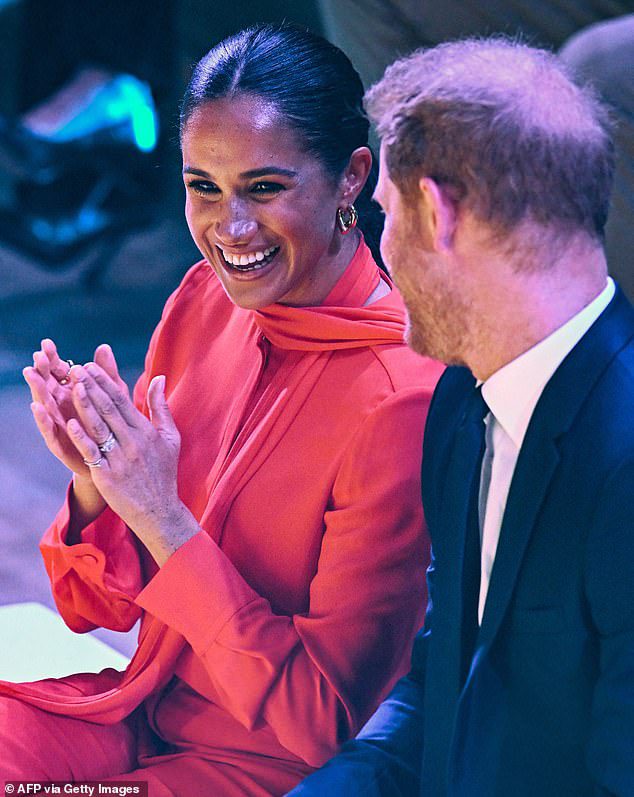 Meghan Markle interage enquanto ouve o príncipe Harry durante o One Young World Summit anual no Bridgewater Hall em Manchester