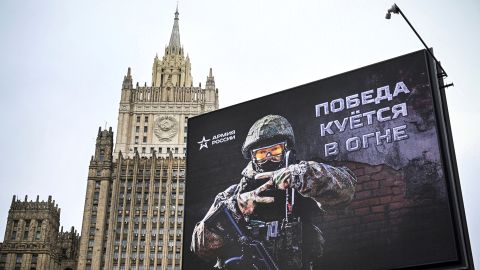 O prédio do Ministério das Relações Exteriores da Rússia é visível atrás de um outdoor exibindo a mensagem 