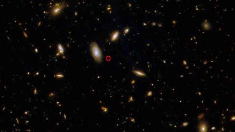 O Telescópio Espacial Hubble capturou esta imagem do local de uma explosão de raios gama, circulada em vermelho.